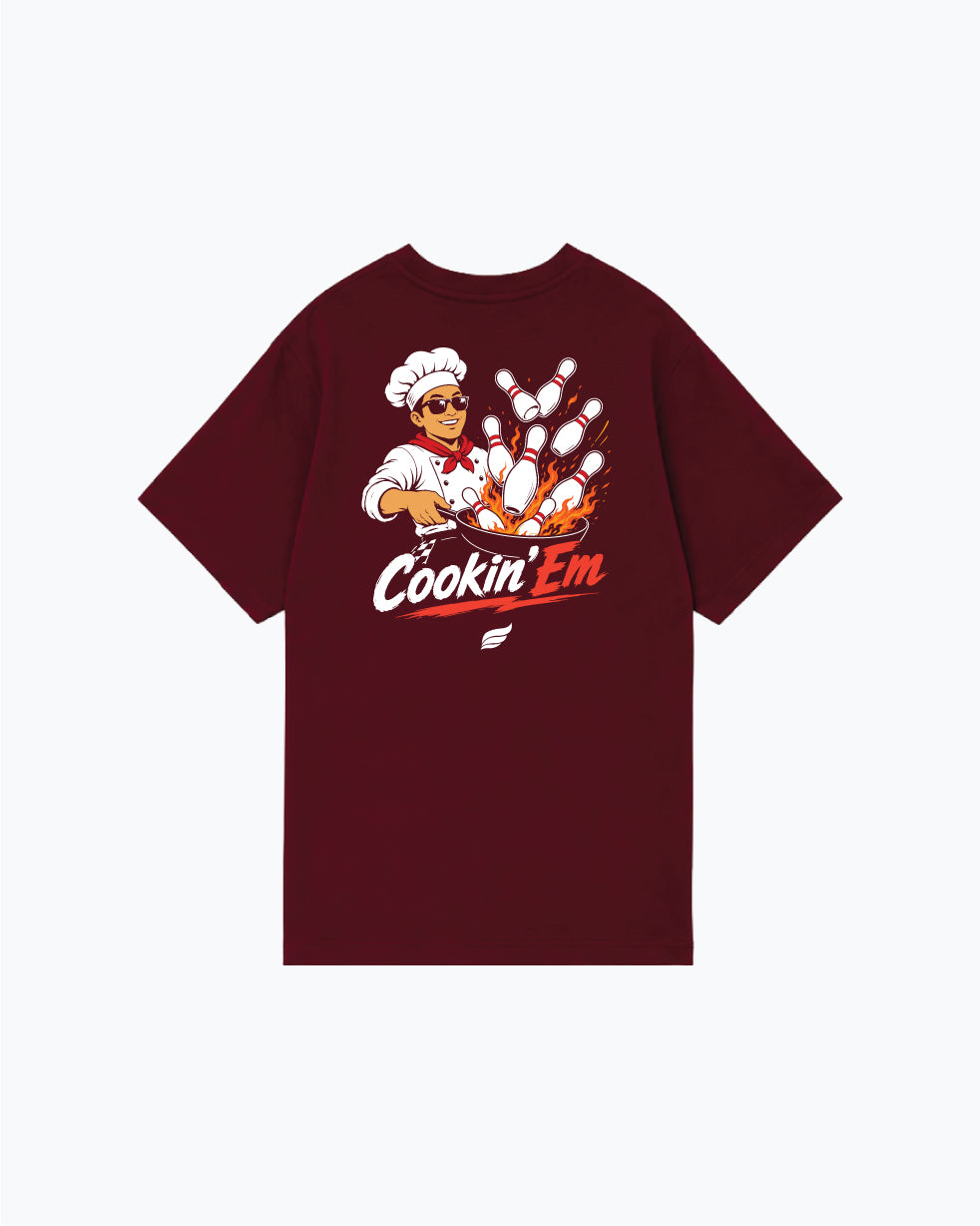 Burgundy t-shirt with cartoon chef and bowling pins graphic, text Cookin Em